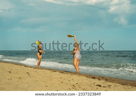 mother and daughter play mat cat on the beach in the summer afte