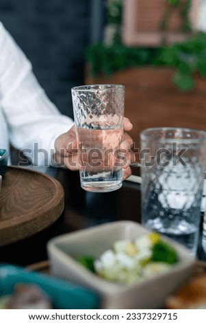 Woman drinking water at breakfast table. water balance