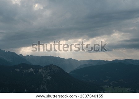 A stunning panoramic shot of the Bavarian mountains under a dramatic cloudy sky, encapsulating the majestic and untamed beauty of this Alpine landscape.