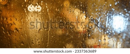 Rain drops on the window glass. View of the Brussels street at night summer time. Concept of the beauty in nature. Panoramic photography