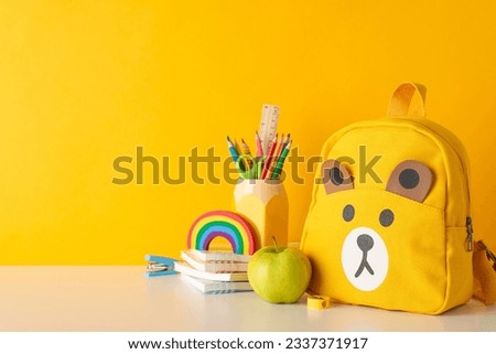 Infuse happiness into education with this side-view picture of vibrant school supplies, penholder and backpack on yellow isolated backdrop, accompanied by ample space for text or ad incorporation Royalty-Free Stock Photo #2337371917
