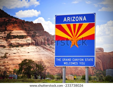 Arizona welcome sign at the state border with red rocks background