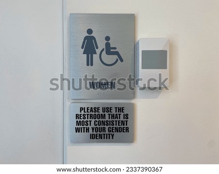 Close-up of women's wheelchair accessible restroom sign that says "Please use the restroom that is most consistent with your gender identity" at Columbia University in New York City