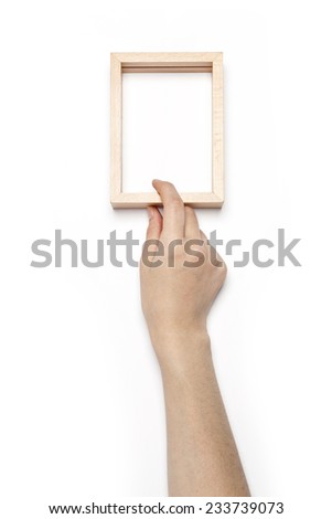 A female hand hold(grip) a wooden photo(picture) frame isolated white, top view at the studio. 
