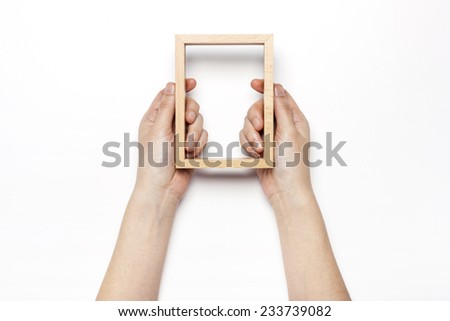 A female hands hold(grip) a wooden photo(picture) frame isolated white, top view at the studio. 
