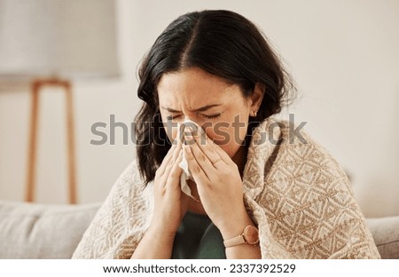 Nose, tissue and sick woman sneezing on a sofa with allergy, cold or flu in her home. Hay fever, allergy and female with viral infection, problem or health crisis in a living room with congestion Royalty-Free Stock Photo #2337392529