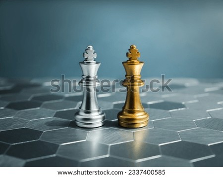Golden and silver king, luxury chess pieces standing together on a silver hexagon pattern chessboard on blue background. Leader, friend, enemy, cooperation, partnership, and business strategy concept. Royalty-Free Stock Photo #2337400585