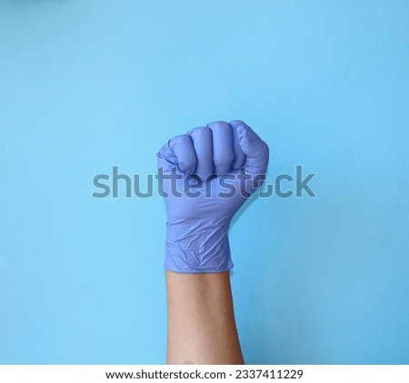 Fist in blue medical latex gloves. Fight against influenza and viruses. Doctor's hand in dentistry and surgery. A symbol of strength, confidence and guarantee. Close-up.