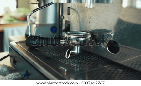 Stainless steel portafilter sitting on coffee machine counter Royalty-Free Stock Photo #2337412767