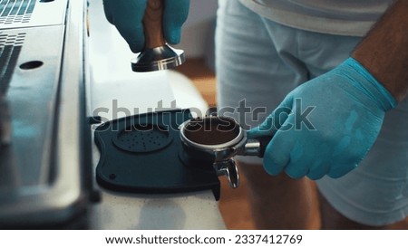 Close up of Barista's hands using coffee press with a portafilter Royalty-Free Stock Photo #2337412769