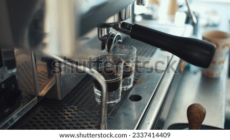Coffee machine pouring coffee into shot glasses Royalty-Free Stock Photo #2337414409
