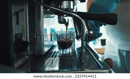 Coffee machine pouring coffee into shot glasses Royalty-Free Stock Photo #2337414411