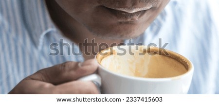 Close up man drinking latte coffee from coffee cup in the morning, banner size