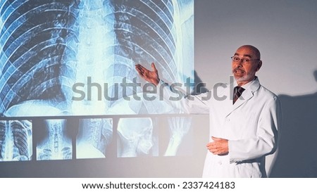 Middle aged Caucasian doctor presenting medical research using a projector screen.
