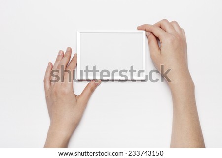 A female hand hold a steel photo(picture) frame isolated white, top view at the studio.
