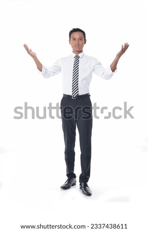 Full length portrait of young businessman open hands standing in studio