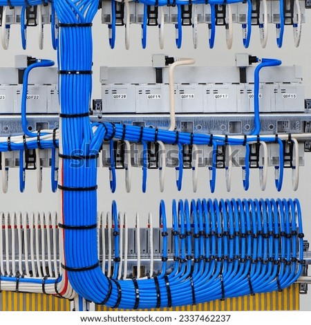 Stranded mounting wires assembled into a bundle with plastic ties. View from the back of the electrical switchboard. Royalty-Free Stock Photo #2337462237