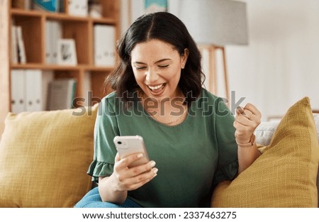 Phone, win and celebration, happy woman on sofa with notification on bonus, deal or discount offer online. Wow, social media and girl on couch with smile, cellphone and excited for surprise in home. Royalty-Free Stock Photo #2337463275
