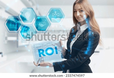 Business, Technology, Internet and network concept. Young businessman working on a virtual screen of the future and sees the inscription: ROI Royalty-Free Stock Photo #2337474597