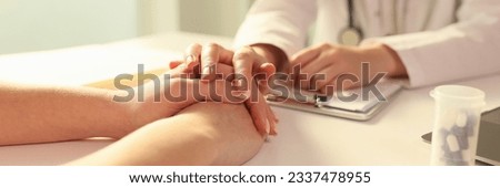 Doctor with his hand calming patient in clinic closeup. Psychological support for incurable patients concept Royalty-Free Stock Photo #2337478955