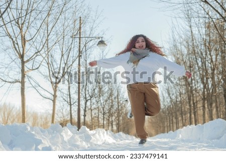 Smiling chubby redhead woman running in park in winter. 