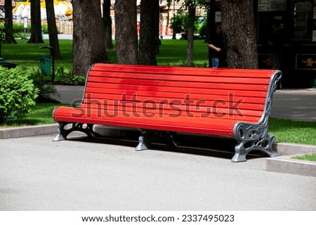 Red Wooden bench in the city park.