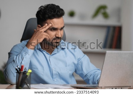 Worried indian Businessman or entrepreneur after seeing mail on laptop at office - concept of work pressure, Business challenges and Uncertain future. Royalty-Free Stock Photo #2337514093