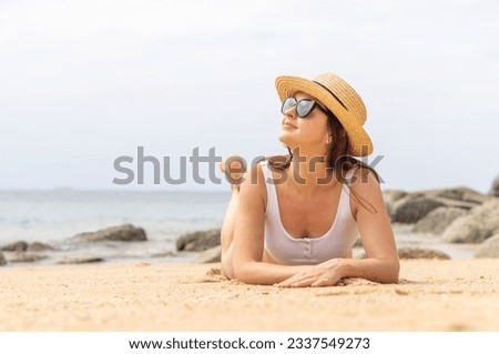 Woman lying on the sea beach enjoying and relaxing in summer