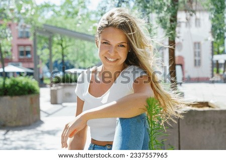  Beauty young woman with white teeth smiling in the street. Summertime