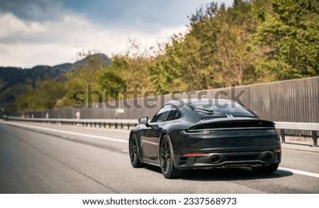 Sleek Black German Roadster. Brand New Luxury Carrera Sports Car on the Highway. Rear view of the 911 GTS sports car. Royalty-Free Stock Photo #2337568973