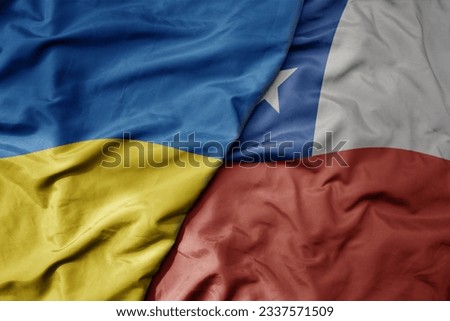 big waving national colorful flag of ukraine and national flag of chile . macro