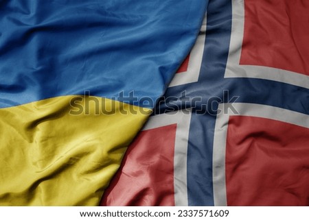 big waving national colorful flag of ukraine and national flag of norway . macro Royalty-Free Stock Photo #2337571609