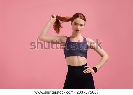 Young woman in sportswear on pink background, space for text Royalty-Free Stock Photo #2337576067