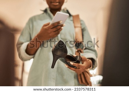 Closeup of young woman taking photo of high heel shoe in clothing store