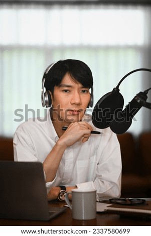 Image of male radio host listening to interesting conversation with guest during recording podcast in home studio