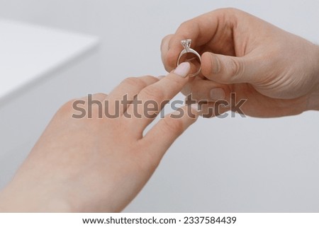 guy puts on the diamond ring of his trouble. Makes an offer. Marriage, cropped image, closeup