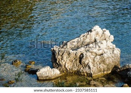 A big rock in the sea near a rocky beach 