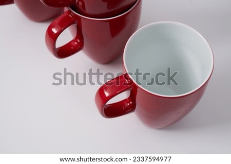 Red ceramic coffee or tea mugs on a white background                                