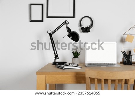 Home workplace. Laptop, lamp and stationery on wooden desk