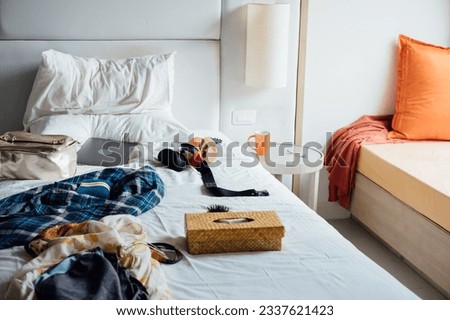 Mess in the room. Women's clothing, computer on the bed. Royalty-Free Stock Photo #2337621423