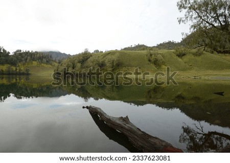 Beautiful lake in the middle of the mountain, among the green trees. The photo was taken by Willem Tasiam, a marathon climber