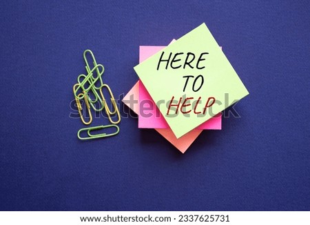 Here to help symbol. Yellow steaky note with paper clips with words Here to help. Beautiful deep blue background. Business and Here to help concept. Copy space. Conceptual word
