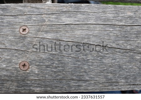 Up close picture of wood from a outdoor bench, screws and worn wooden texture