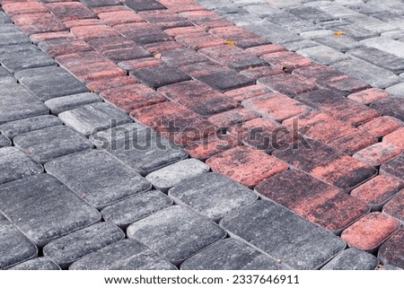 Laying paving slabs of different sizes with rounded corners and uneven surface coloring along a rounded path.