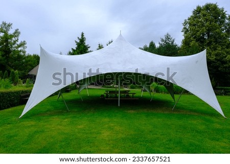 white tarpaulin stretched, shaded from sun and rain. For holding various events in the garden Royalty-Free Stock Photo #2337657521