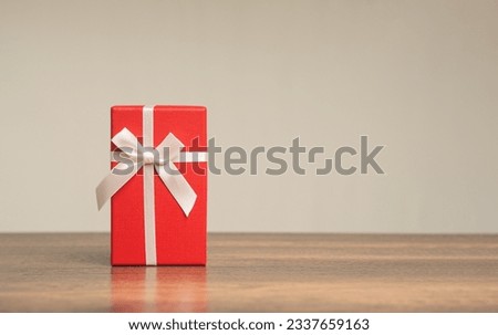 Gift of Joy. Red gift box on wooden table - Perfect for Christmas, celebrations, holidays, and special occasions