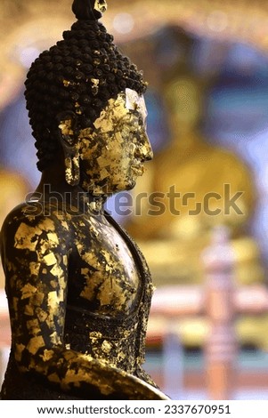 Side of a gilded Buddha image in a Buddhist temple in Thailand Royalty-Free Stock Photo #2337670951