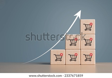 Wooden cubes with shopping cart icons and increasing trend-up graph. Increase higher sale volume and shopping trolley cart for online ecommerce business and internet  marketing strategy concept.