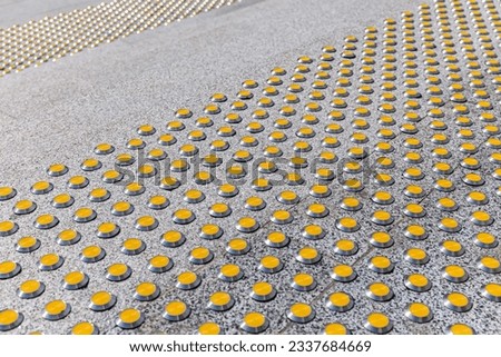 steps of a granite staircase with yellow tactile nonskid markings. closeup view.