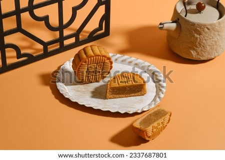 Moon Cake Mid Autumn Festival with teapot on orange background ,chinese style photograph